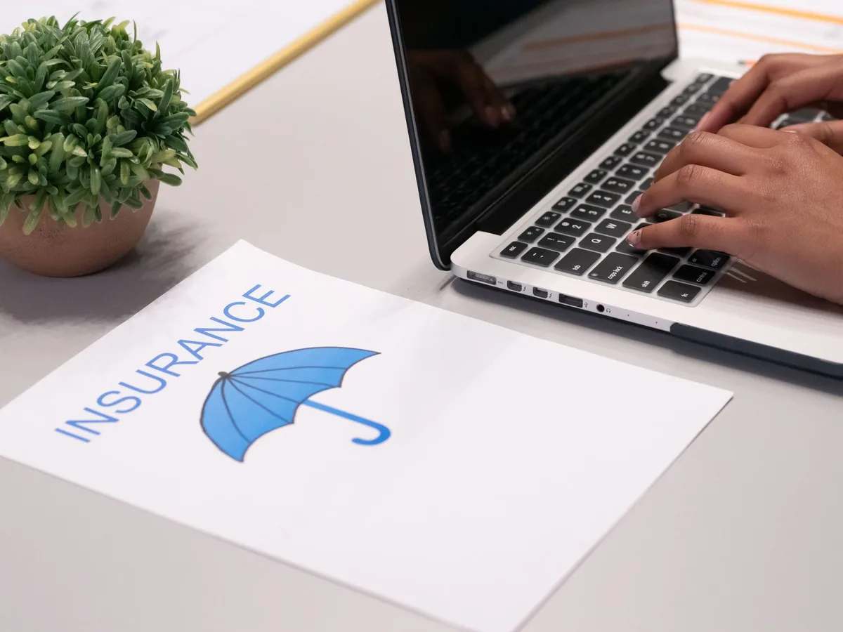 Person reviewing car insurance documents with a calculator