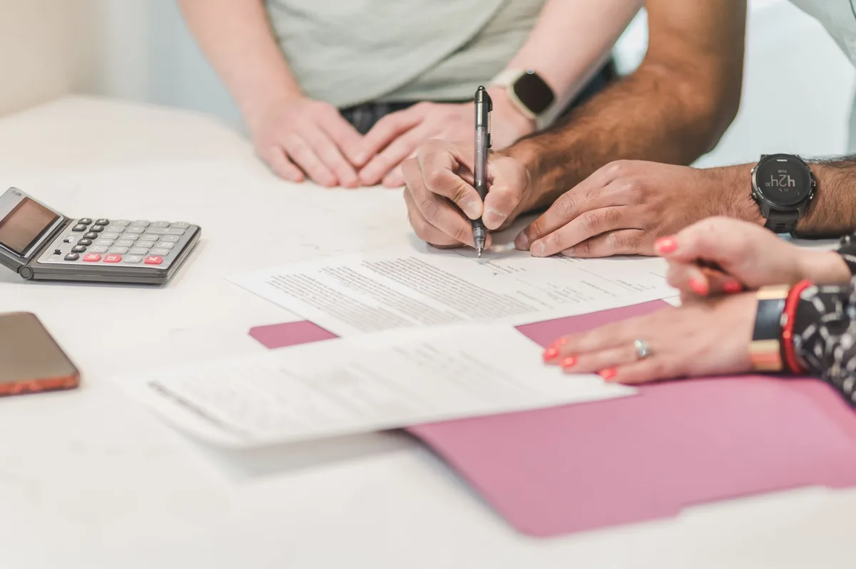 Person reviewing insurance documents and financial planning materials