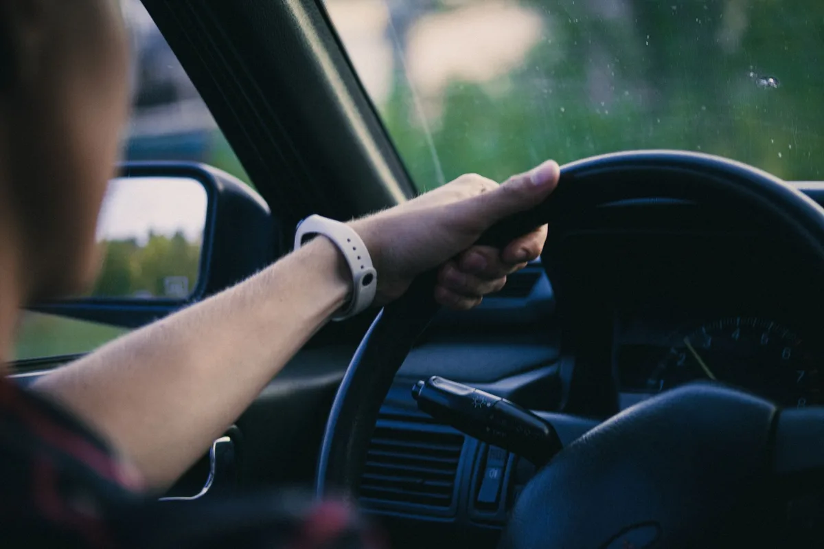 Person learning to drive with hands on steering wheel