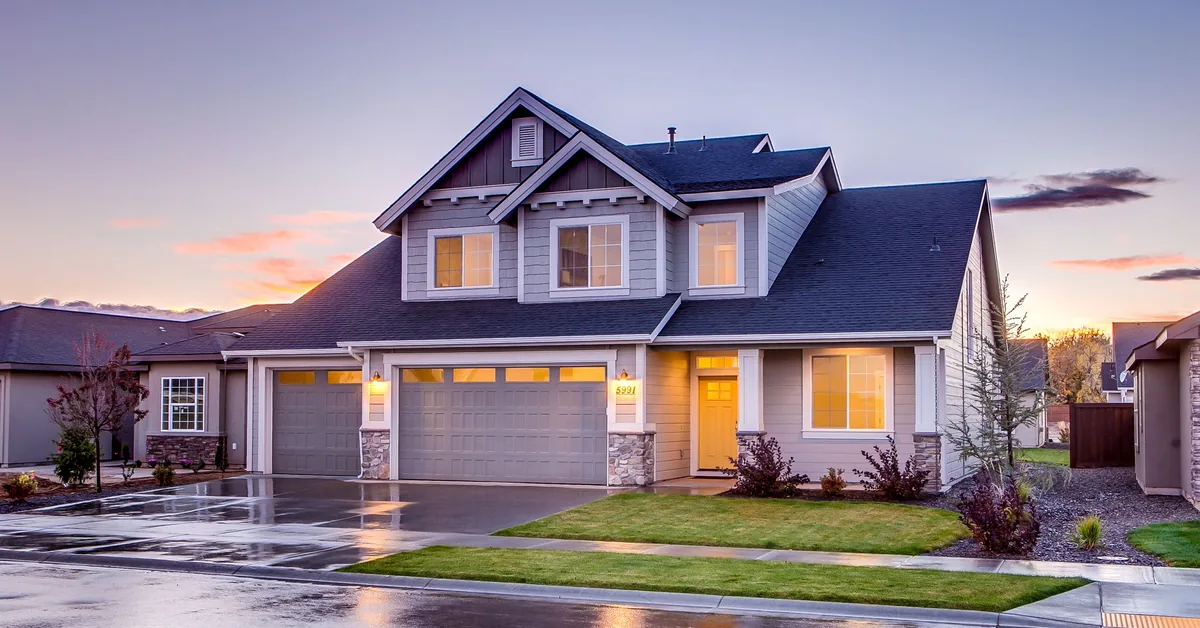 House model with insurance paperwork and calculator showing rising premium costs