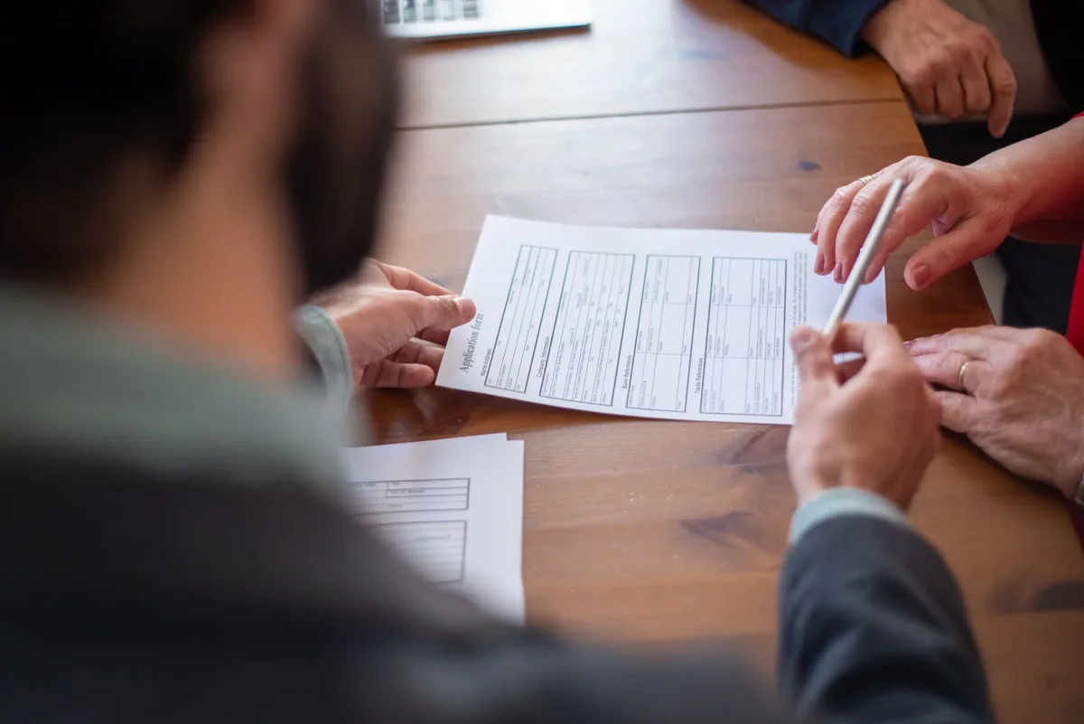 Two business professionals reviewing documents during a consultation meeting
