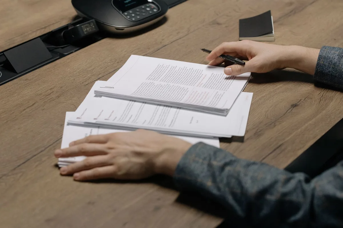 Documents and pen on desk representing benefits review during open enrollment