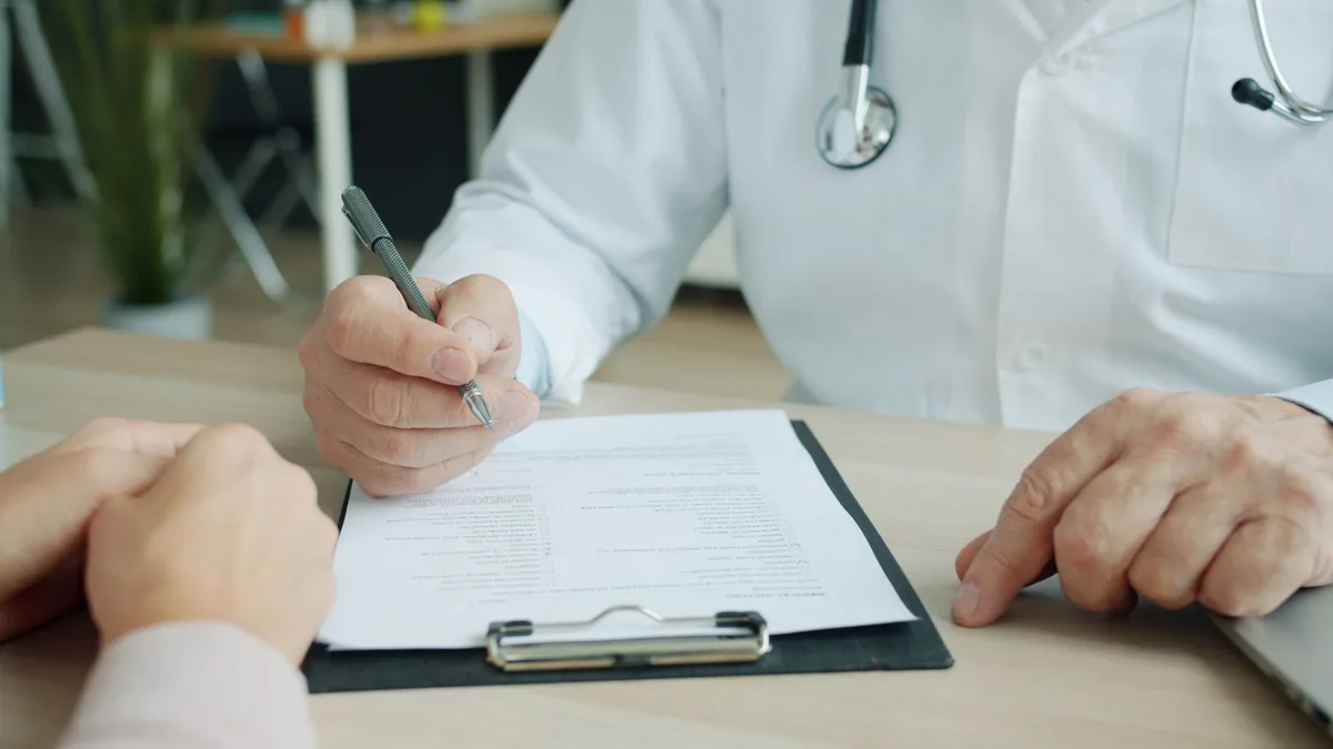 Medical stethoscope and health insurance documents on a desk