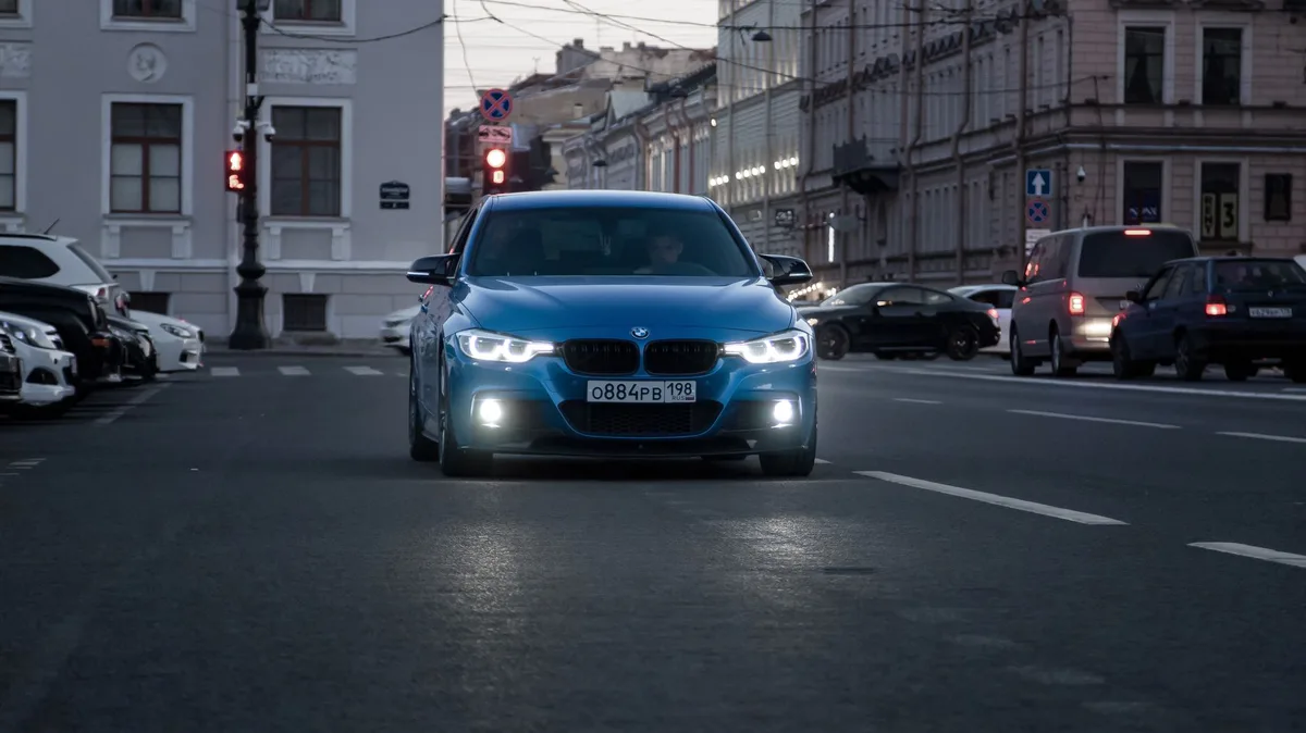 Modern car driving on urban Canadian street representing auto insurance costs