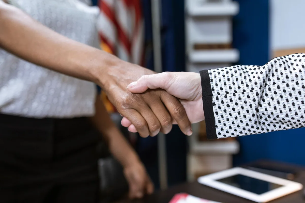 Two business professionals shaking hands in a professional setting