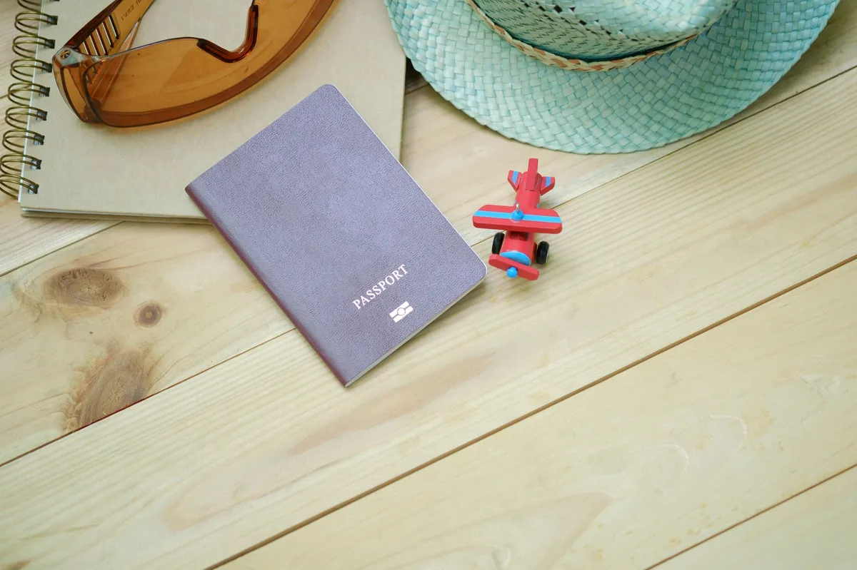 A person planning travel with a notebook and pen on a desk