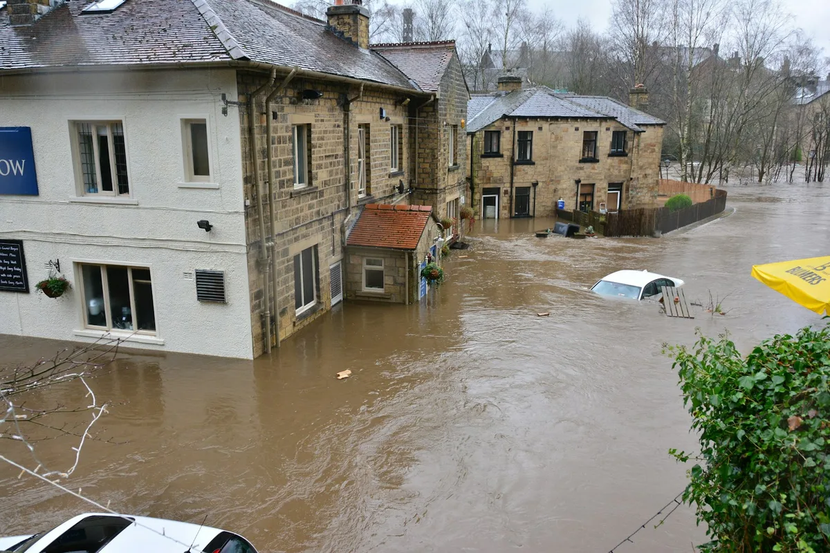 Floodwater covering a residential street after heavy rain.