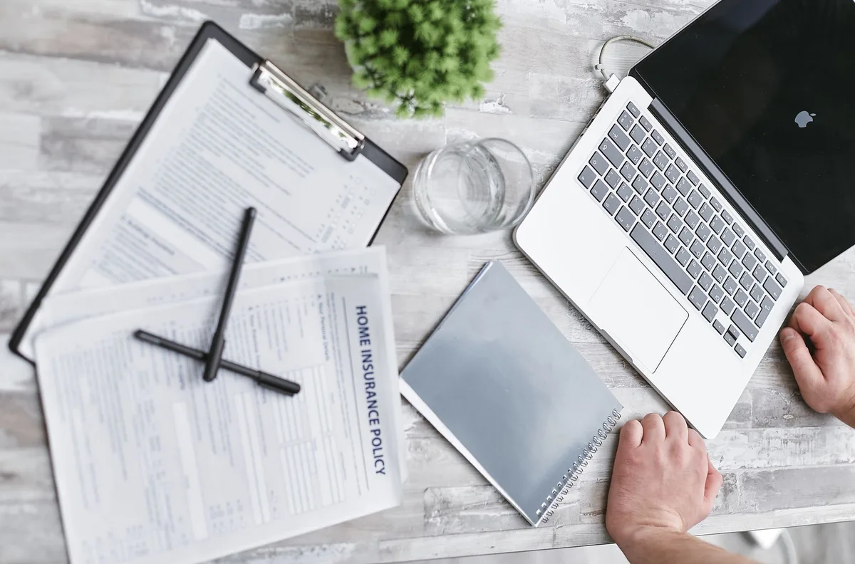 Car insurance documents and policy paperwork on a desk