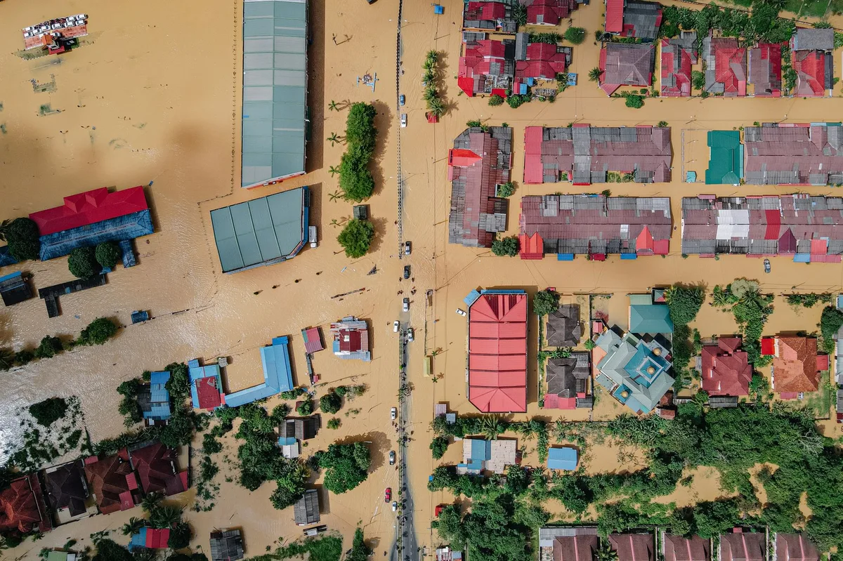 Flooded residential street with water covering the road and surrounding homes
