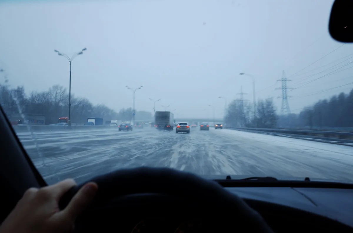 Car driving on a highway representing year-round auto insurance protection